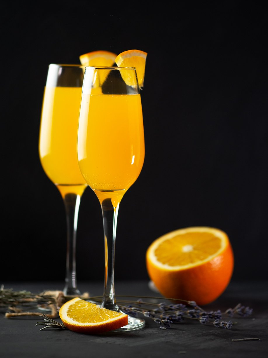 Mimosa drink with orange juice and champagne on a black background